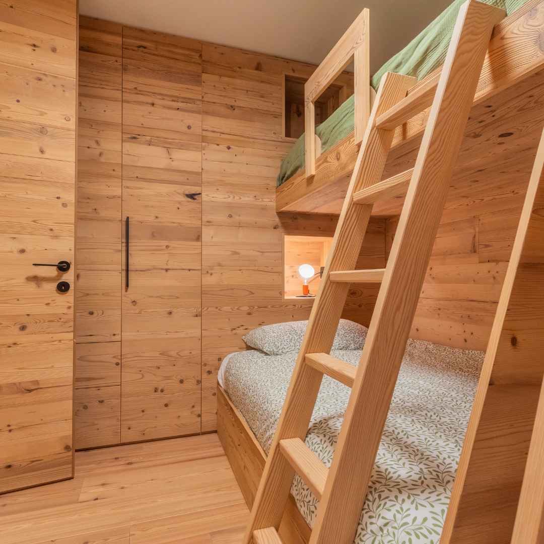 Camera di montagna con letto a castello e armadiatura in legno