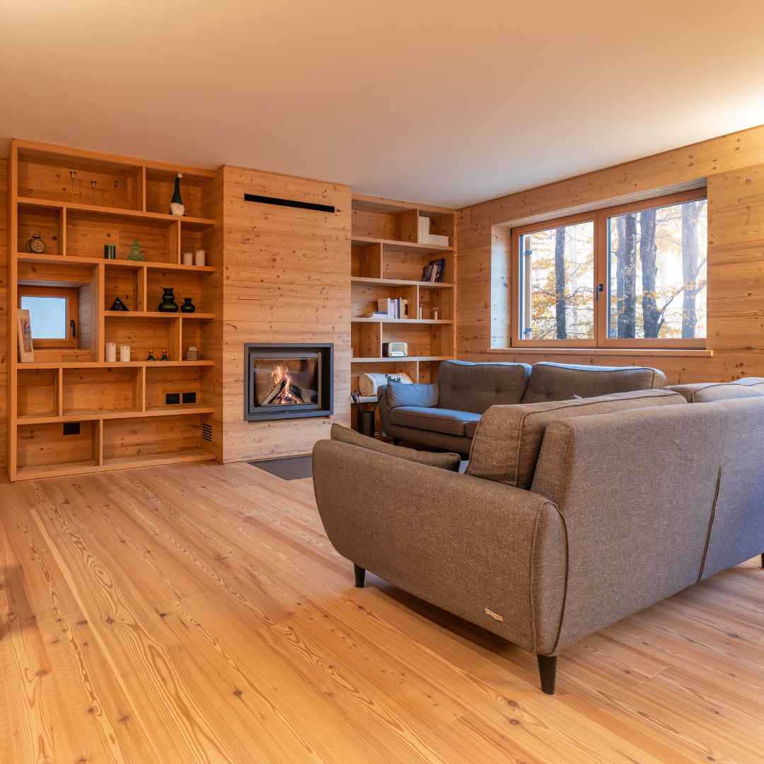 Soggiorno su misura in legno di montagna con camino e scaffalature