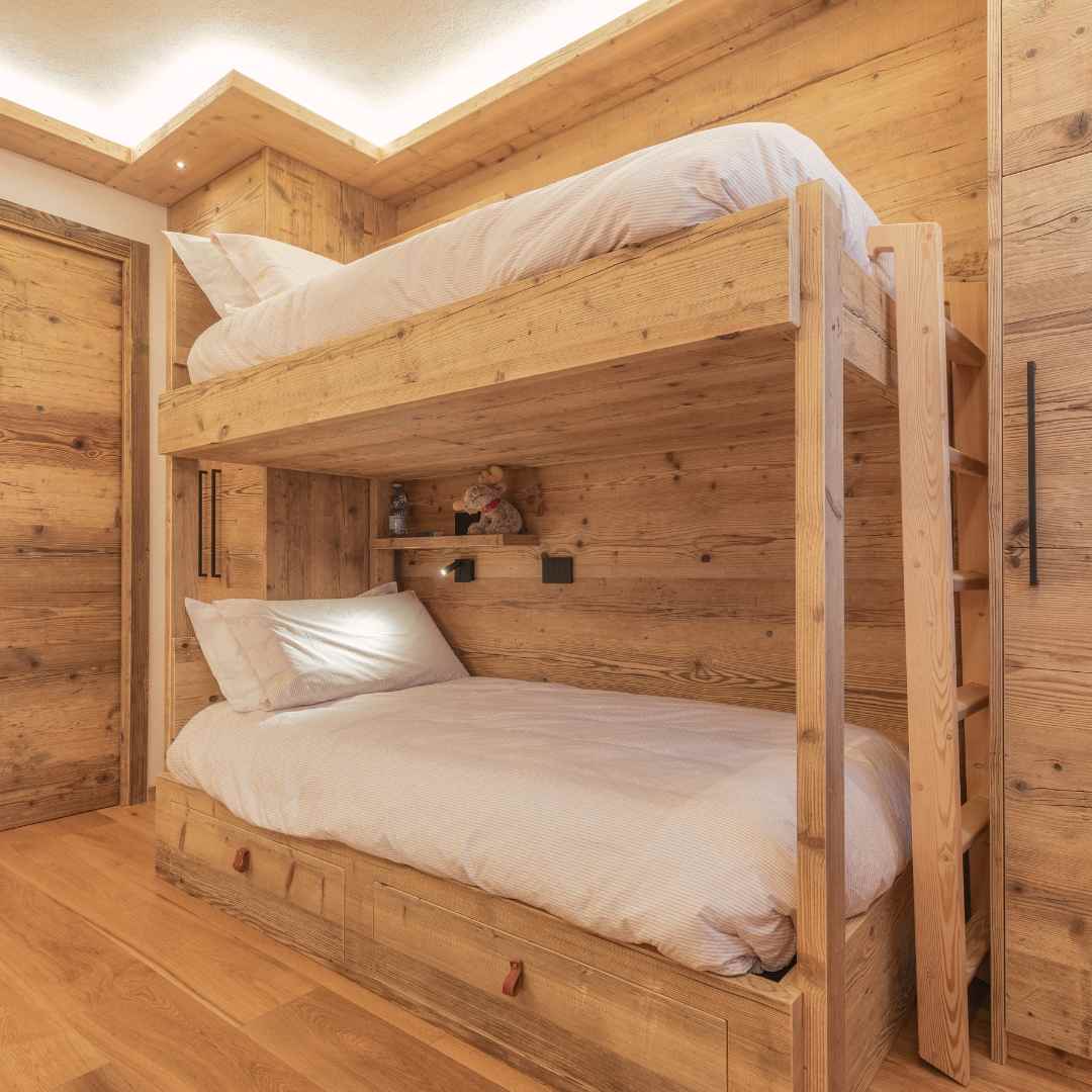 Letto a castello in legno in una cameretta rivestita di legno