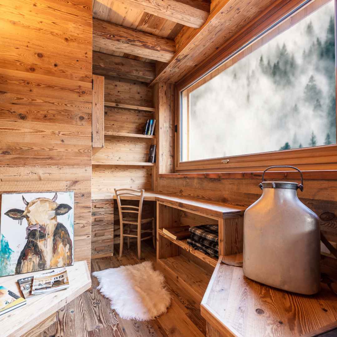 Rivestimento in legno di montagna su misura con scaffalature e scrivania